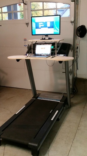 The original treadmill desktop prototype, mounted on a treadmill with a double-decker of metal shelf-bracket risers holding the monitor at eye level.